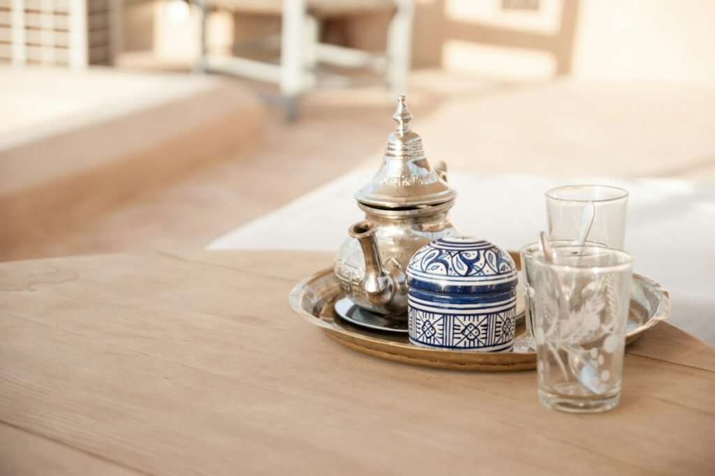Silver teapot and tea glasses on a riad rooftop table
