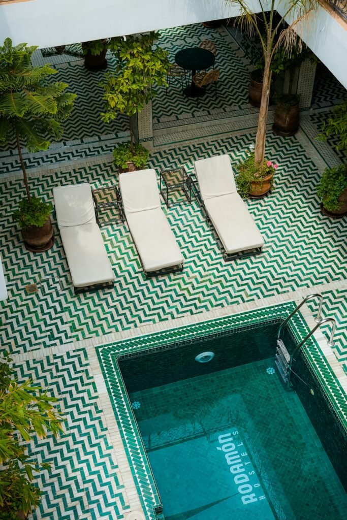 Riad courtyard pool with green zellige tiles in Marrakech, where the Morocco honeymoon package begins