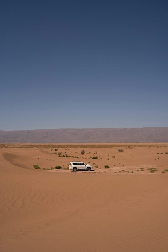 White 4x4 on a sandy desert track, the way from Zagora to Erg Chigaga beyond M'hamid